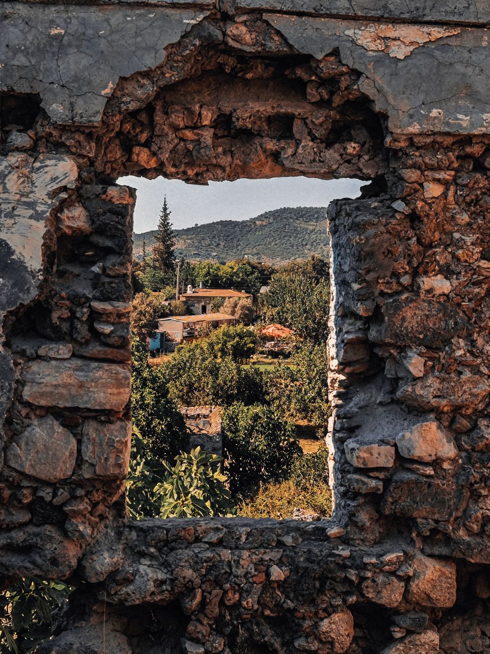 Travel essayist sitting near an open window overlooking mountains