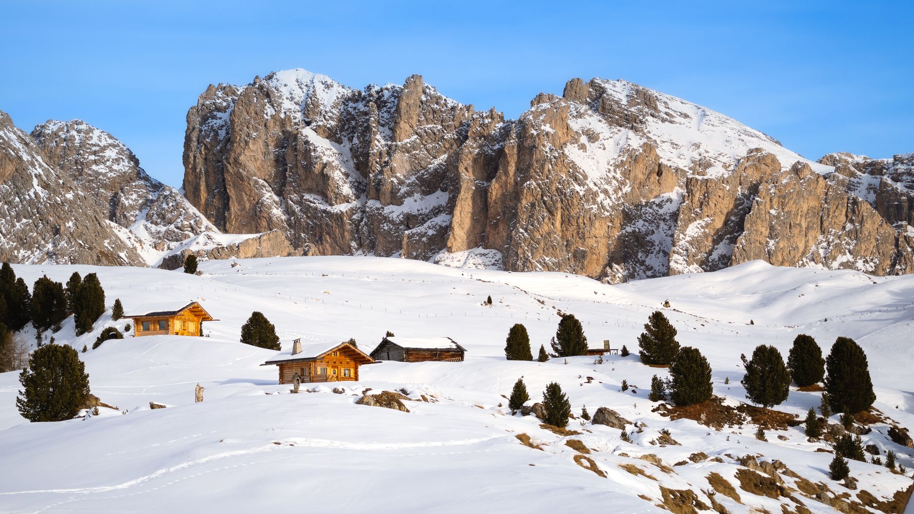 Majestic limestone peaks of the Italian Dolomites surrounded by golden meadows